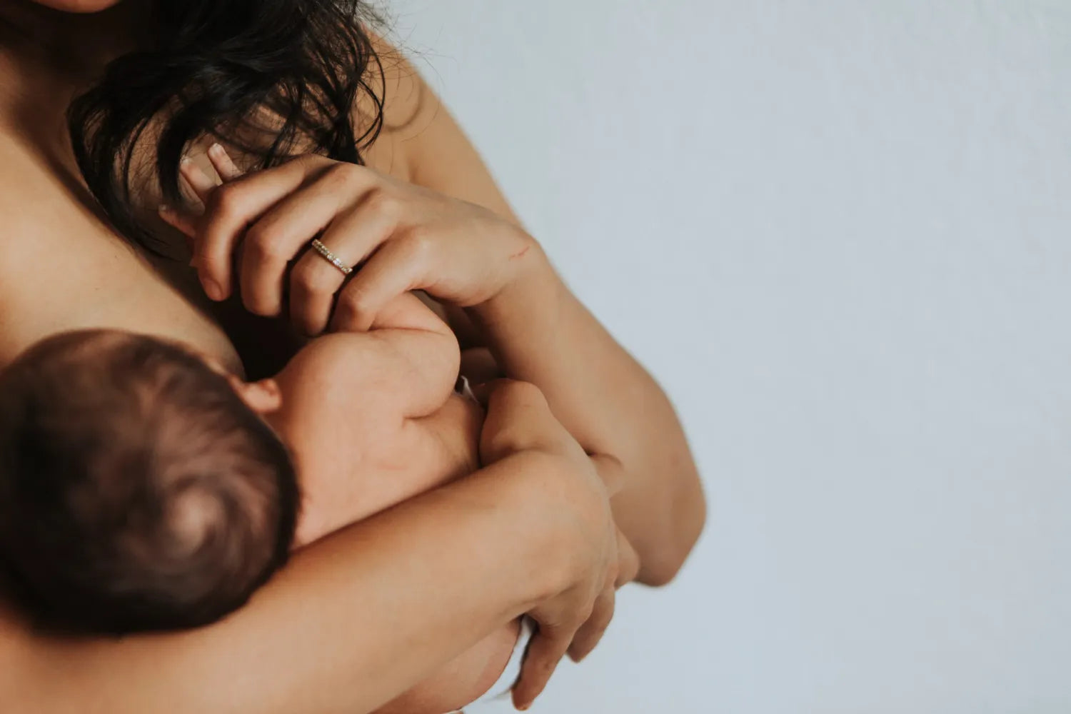 Close up of mother breastfeeding infant, natural newborn feeding and maternal bonding scene