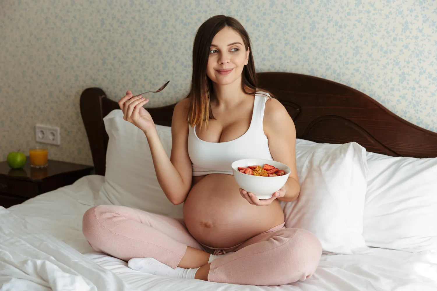 Pregnant woman enjoying fresh fruit cup at home, mindful maternity nutrition and healthy eating routine