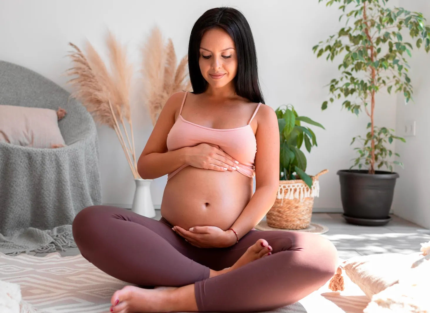 Pregnant woman sitting cross legged at home, peaceful maternity lifestyle and self care routine