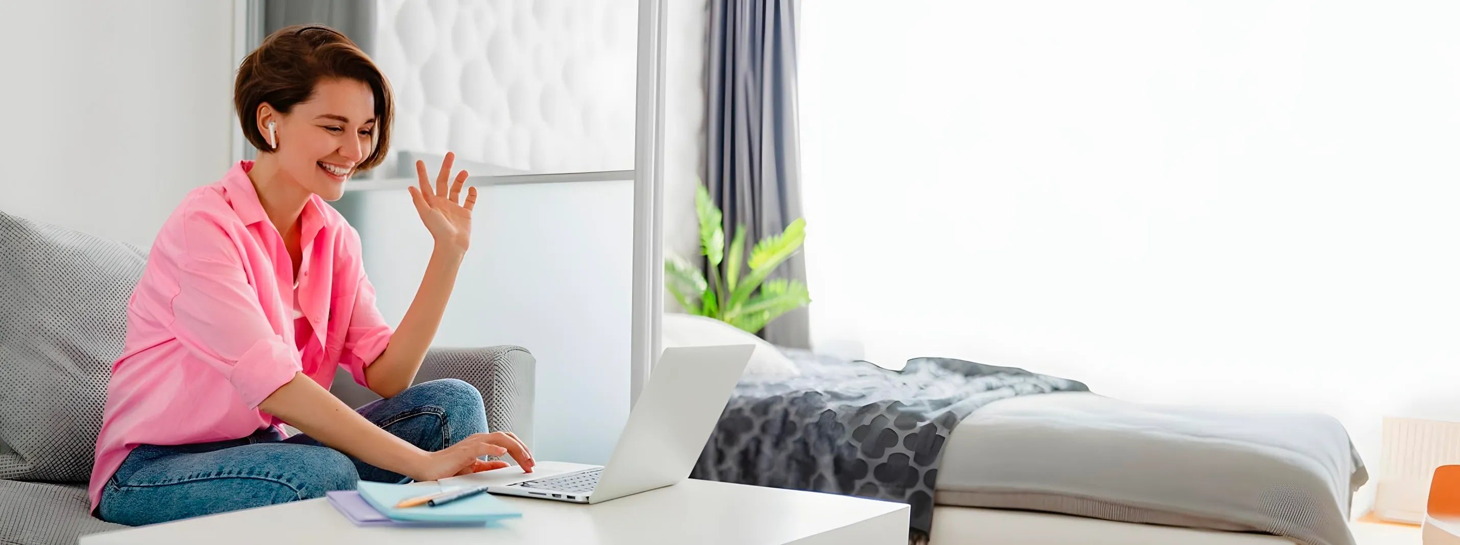 Pregnant woman working from home on laptop wearing pink shirt, representing modern motherhood lifestyle