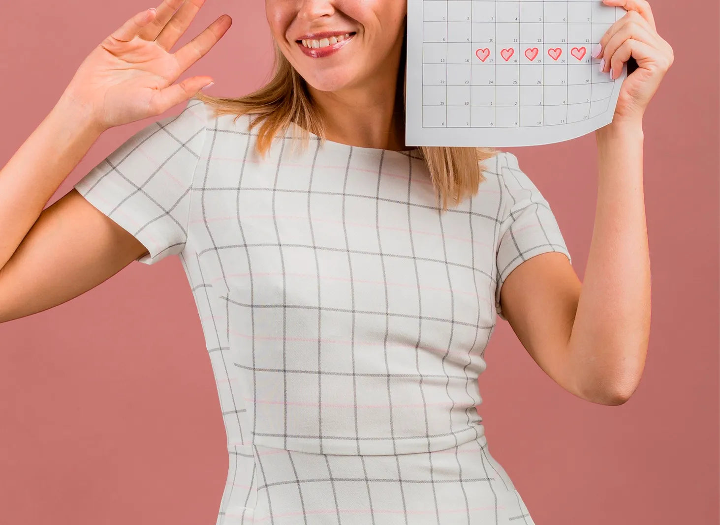 Woman holding calendar with marked dates, pregnancy planning and fertility awareness concept
