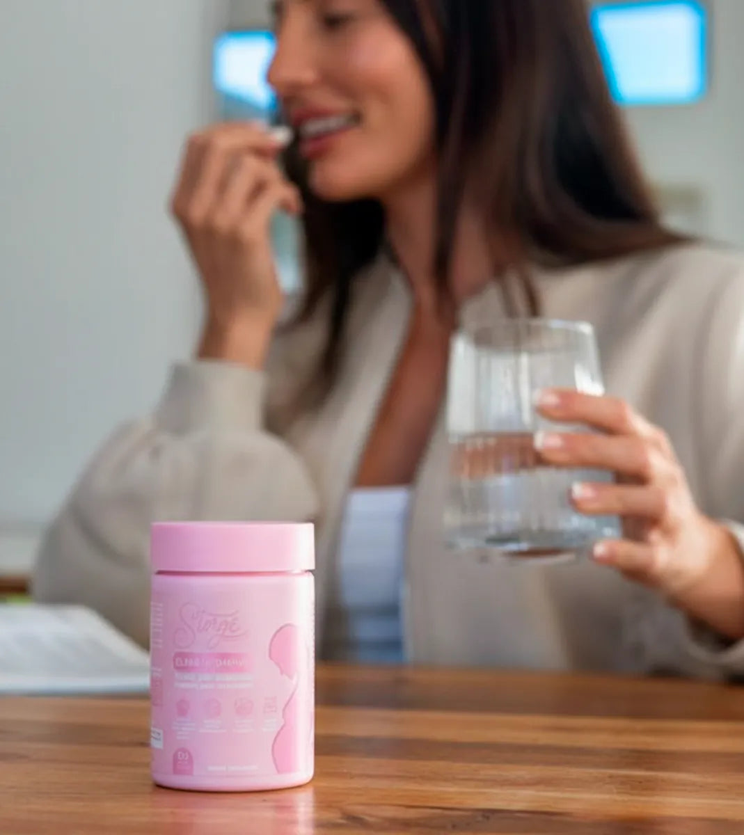 Woman taking prenatal vitamins with water, Storgé Elara daily maternity supplement routine